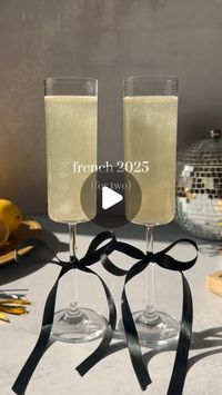 Lauren Milovich on Instagram: "The French 75, but make it 2025! 🥂

This is the perfect cocktail to sip on into the new year - and it’s all tied up in a cutie bow! 

Here’s how to make it:

• French 2025 •
(For two)
Tie bows around base of flutes
3 oz gin
1.5 oz lemon juice
1 oz simple syrup
Edible glitter
Shake w/ ice
Strain into champagne flutes
Top w/ champagne
Enjoy!

#thatsthespirits #french2025 #french75 #champagne #gin #newyears #newyearseve #newyear #happynewyear #2025 #cocktail #drinkrecipe"