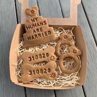 Want to a unique gift to celebrate a couple's marriage? Get the dog involved with the celebration with these unique dog treats! These personalised dog treats make a great unique wedding gift and involves the dog(s) in the celebration of the new couple! This gift set includes: - 2 'My / Our Humans Are Married' Wedding Cake Biscuits - 2 Rings Biscuits - 2 Personalised Date Bones Biscuits (DD/MM/YY) Freshly baked to order, all of our biscuits are hand stamped with our Afternoon Paws signature 'Paw