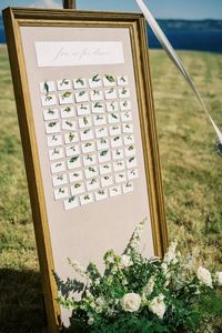 A sprig of herb greenery pinned to each of the name cards on this large framed seating chart is the kind of thoughtful detail we love in an event. With a floor standing floral arrangement at the base filled with greenery and white floral, a perfect thing for an outdoor summer PNW wedding.