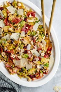 Beautiful warm brussels sprouts salad tossed with crispy bacon, toasted hazelnuts and a light lemon dressing. This cozy twist on a classic shredded brussels sprouts salad is full of flavor and makes a wonderful lunch or holiday side dish! #salad #brusselssprouts #thanksgiving #lunch #lowcarb #sidedish #glutenfree #grainfree