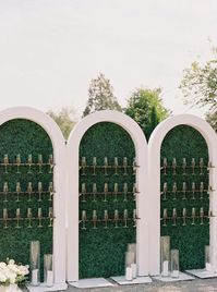 Champagne wall greets guests during this outdoor summer wedding, decorated with candles and white floral arrangement it's a luxury touch.