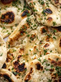 This garlic butter naan bread recipe is divine! It uses baking powder and baking soda instead of yeast and is drenched with garlic butter. So delicious!