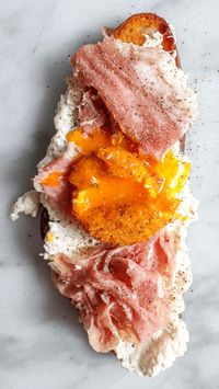 This fried egg yolk with burrata and prosciutto on toast is what brunch dreams are made of!