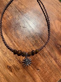 ~Hemp macrame sun charm beaded choker  necklace.  ~Length~  14-16 inches ~Sun symbol represents abundance, warmth, and new beginnings ~Tigers eye for self-confidence and inner strength. ~Each intricate knot and carefully chosen bead was crafted with positive energy and precision, making this piece a true work of art.