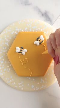 Decorate a bee themed hexagon cookie with royal icing transfers.