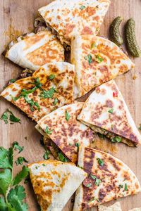 Philly Cheesesteak Quesadillas - Done in under 30 minutes and a make-ahead recipe. Flour tortillas filled with steak and cheese cooked until the tortillas as crisp and cheese is melted. #phillycheesesteakquesadilla #cheesesteakquesadilla #quesadillarecipe #quesadillas #natashaskitchen