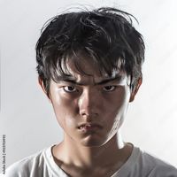 Download Angry, emotional and furious Asian man in white t-shirt makes a fierce grimace on his face. Japanese man shows visible anger Stock Photo and explore similar images at Adobe Stock.