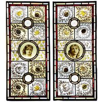 A large pair of Arts and Crafts style floral stained glass panels depicting young female faces. Dating to circa 1890, these panels are competently painted