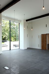 Double height glass doors to a threshing barn conversion. The double height glass doors sit within the old threshing barn door way for a full height glass door that slides open. Click on the image to see the full project images for this barn conversion. 