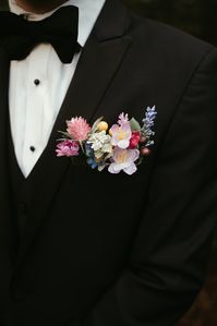 Who says flowers are only for the girls? We love the detail of a floral pocket on this classic black suit! The floral design adds so much interest for the groom!