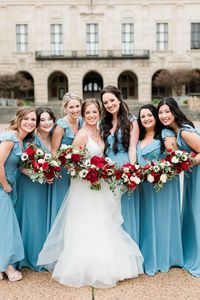 winter wedding in downtown Austin with blue bridesmaids dresses and red and white flowers