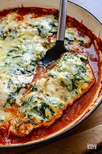 This Ricotta Spinach Topped Chicken is a family-friendly recipe - tender chicken breasts resting atop a luscious tomato sauce, crowned with a generous dollop of creamy, garlicky ricotta cheese, and spinach.