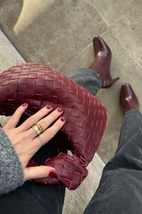 Matching burgundy bag and ankle boots, paired with grey knitwear and jeans.