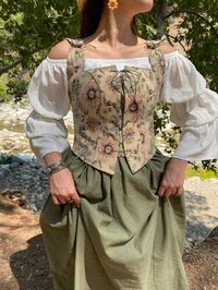 Perfect for Renaissance Faires, Halloween, Cosplay, or just frolicking around a field, this corset will be a timeless addition to your costume wardrobe. Medieval corset with blue and salmon floral print and green tones. Made with tapestry fabric. For White Dress; https://www.etsy.com/listing/1221803409/cotton-silky-renaissance-dress Do not hesitate to contact us for the complete combination. This corset bodice is made of two layers:  with a %100 Tight weave cotton canvas lining . The outer fabric is strong and breathable, and this corset will withstand many wears for years to come. It ribbon up for easy adjustability at the center front. It comes with a two different color ribbon sets. Body-shaping synthetic boning Removable modesty panel so you can wear your corset with or without additio