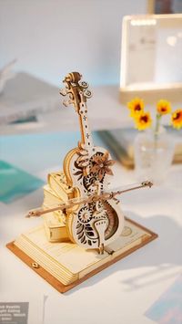 With a romantic retro style, this Magic Cello music box is mainly a combination of cello and magic book. The hollow structure of the body shows the internal gear set, six-petal flower embellished on it, and the panel is engraved with a classic European pattern, very retro aesthetic. The product is also interspersed with a large number of magic elements, such as magic books, little witches and cats, giving people a retro and mysterious visual experience.