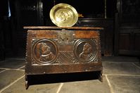 THIS FINE ENGLISH TUDOR CHEST HAS A SINGLE PLANK TOP ABOVE A FRONT BEAUTIFULLY CARVED WITH TWO MEDALLION HEADS WITHIN ROUNDELS, EACH CORNER WITH LEAF AND BUD DECORATION AND CENTRAL SLANTED CARVING. THE SHAPED TAPERED ENDS WITH CUT-OUT GOTHIC ARCHES TERMINATING WITH CROSS DECORATION.