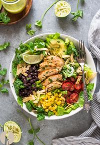 Santa Fe Chicken Salad with Tangy Lime Dressing is a fresh, hearty salad packed with black beans, roasted corn and tortilla strips tossed with a zesty lime dressing! #salad #glutenfree #chickenbreast