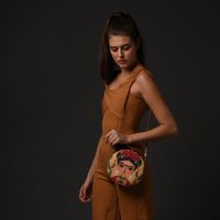 The bag in the image features a striking and colorful portrait of Frida Kahlo, a beloved artist known for her bold self-portraits and Mexican folk art influences. The round cross-body design gives it a unique shape, making it not just a practical accessory but also a statement piece. With the vivid embroidery and attention to detail, this bag can add an artistic touch to any outfit, blending functionality with cultural flair.