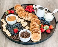 For more tasty recipe ideas visit our Bio link  A Silver Dollar Pancake Board is a delightful way to serve mini pancakes and an array of toppings for a fun and interactive breakfast or brunch experience. Here's a basic recipe and ideas for assembling your pancake board:  Ingredients:  For the Silver Dollar Pancakes:  1 cup all-purpose flour  2 tablespoons sugar  1 teaspoon baking powder  1/2 teaspoon baking soda  1/4 teaspoon salt  1 cup buttermilk  1 large egg  2 tablespoons unsalted butter, melted  Cooking spray or additional butter for the griddle  For the Pancake Board Toppings (customize as you like):  Maple syrup  Fresh berries (strawberries, blueberries, raspberries)  Sliced bananas  Chocolate chips  Chopped nuts (e.g., pecans, walnuts)  Whipped cream  Nutella or other spreads  Gree