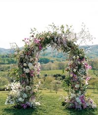 Lush, overgrown garden arch for a spring wedding in Virginia. Bridgeton-inspired, romantic wedding. Purple and white wedding flowers - full ceremony arch.