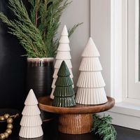 Not all holiday displays need glitter and shimmer. Some of the best are quiet and peaceful—like a new-snow morning with fresh reindeer tracks, or a sleepy child asleep beside a fire. Matte white ceramic trees in three sizes make for a graceful and gracious season.