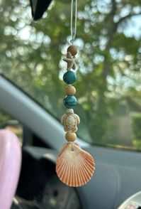 Coconut scented all natural wood beads. Rear view mirror beachy car charm freshener. Mermaid beach decor car accessory perfect summer feel and scent - some are real Florida seashells(scallops/flats) collected by us.  Several designs to choose from in variations with pictures. Car accessory to remind you of the beach. Hang from your car, office or shower. Each hanger will come with scented wood beads .  Car diffuser-Wooden beads are coconut scented with essential oils - you can reapply any oils s