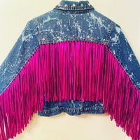 Bleached and distressed denim jacket with fuchsia fringe down arms and back adorned with silver studs.  Arm only fringe is also available