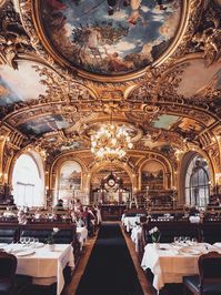 Hop aboard the EuroStar and say bonjour to Le Train Bleu. You’ll need to pick your jaw up after you learn this is a restaurant within a Parisian train station. The building was originally constructed for the World’s Fair of 1900 and became a full time restaurant in 1963. Since then, it’s been cooking up traditional French cuisine underneath arresting panels of murals, gilt moldings, and ornate chandeliers. We’ll take un verre de vin and pretend we’ve stepped back in time to La Belle Epoque!