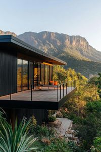 Modern mountain house with black cladding with stunning tropical mountain views. Check out these stylish and cozy black modern mountain houses that blend sleek design with rugged charm. These are stunning dream retreat homes.