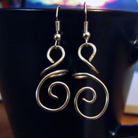 These DIY hanging wire swirl earrings are the perfect pair to wear out on the town, on your first date, or to a work event. You can make them yourself, too!