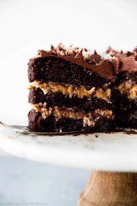 This German chocolate cake has a gooey coconut and toasted pecan filling, a dark chocolate cake, and deliciously creamy chocolate buttercream on top!