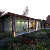 This timber and glass barn extension creates a modern living area to the rustic barn building. Using slim framed sliding glass doors from IQ the barn extension connects with the large gardens and maximises light. Rustic timber posts sit in front of the sliding glass doors and provide the appearance of an open barn extension structure. Click on the image to see more examples of this project on the case study