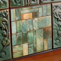 This exquisite ceramic tile array presents a stunning collage of glazed squares, each telling a story in shades of sage, seafoam, and eucalyptus green. Accents of amber gold and specks of sand beige offer a warm contrast, while the crackled texture provides a rustic, time-worn appeal. The rich cinnamon and espresso borders frame each tile, lending a grounded depth to the composition. A golden tile stands as a centerpiece, its metallic sheen reflecting light and drawing the eye. Perfect for those looking to infuse their space with a touch of organic elegance and artisanal charm, this tile is a testament to the beauty found in the imperfections of nature and the artistry of human craft.