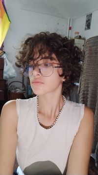 Trans masc no binary androgynous curly hair mullet haircut teen boy photo idea drawing reference fairy core elf punk rock alt style aesthetic photo mirror selfie capelli castani cioccolato caldo taglio di capelli Brown hair Eyeglasses haircut