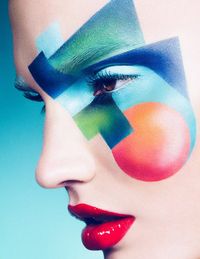 Blend of bold colours and shapes on the face against a pale face- abstract and innovative make-up- a different way of representing someone