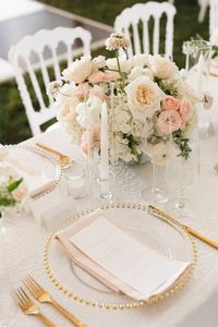 French Country Chairs with white and blush details, gold flatware, rattan lanterns and greenery and Gardenia White Linen from Peak Event Services