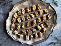 Easy vegetarian stuffed dates with creamy goat cheese, crunchy nuts, a sweet drizzle of honey, and savory pop of thyme - the best appetizer!