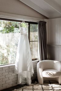 Gorgeous photograph of one of our beautiful bride's wedding dresses displayed in The Dairy Accomodation at The Fig Tree Restaurant in Byron Bay. Photograph by Shane Shepherd.