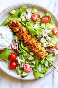 This Mediterranean inspired salad is made with Grilled Chicken Shawarma kebabs served over salad with Feta and Tzatziki.