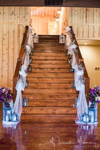 Gorgeous wedding staircase decor for a lavender wedding!  Love the tulle draping, lavender bouquets, and lanterns.  Elegant and unique wedding decor!  Perfect frame for your reception hall entrance. Taken at THE SPRINGS in Tulsa.  Follow this pin to our website for more information, or to book your free tour! Photographer:  My Treasured Memories Photography #weddingstairs #weddingstaircase #weddingdecor #weddingdecorations #receptiondecor #receptiondecorations #weddingreceptiondecor