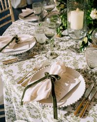 Sunlight whispers across this elegant tablescape, while soothing green tones set the mood for an evening of unforgettable memories | Featuring: Fern Amara Linen and White Hemstitch Napkins | wedding planning, wedding inspo, wedding decor, wedding reception decor, wedding tablescapes, wedding table decor, wedding table ideas, wedding linens, linens for wedding, wedding tablecloths, linens for events, luxury linens, patterned linens, elegant wedding decor, 2024 wedding