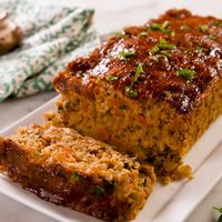 This hearty "meat loaf" is packed with veggies and protein. We're in love! Serve it with a side of rosemary roasted potatoes and oven-roasted brussels sprouts for a truly delicious (and suuuper nutritious) vegan feast! Get the recipe at Delish.com. #delish #easy #recipe #best #vegan #meatloaf #chickpea #simple #mushrooms #thanksgiving #