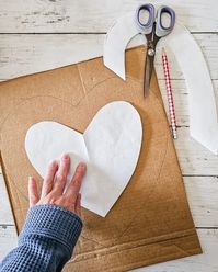 This heart shaped wreath is made from paper bags and cardboard! The paper roses are a wonderful way to add romantic, neutral Valentines Day decor. Full tutorial at diybeautify.com!