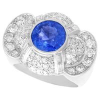 A stunning vintage 1950s 3.57 carat sapphire and 2.37 carat diamond, platinum cocktail ring; part of our diverse gemstone jewelry and estate jewelry collections. This stunning, fine and impressive sapphire and diamond ring has been crafted in platinum. The substantial, shaped setting is ornamented with a feature 3.57Ct round mixed cut blue sapphire, bezel set in subtle relief to the center. eight channel set baguette cut diamonds emanate from the central sapphire, displayed in pairs. The surroun