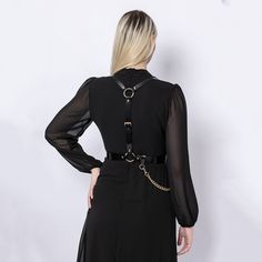 A harness designed to be timeless, the Chained Harness is handcrafted from real Italian leather.  Adjustable at waist and shoulders, the piece beautifully frames the torso, creating a stylish and empowering look. With a detachable chain draping on the waist, you can style the harness over a dress, shirt or even a blazer. Handcrafted in EU using Italian Full Grain Leather and Nickel Plated Hardware        It is recommended to clean the products after each wear as follows:  The leather parts should be wiped with a soft cloth, slightly damp, and let dry at room temperature the metallic elements should be well wiped with a dry cloth  It is NOT recommended to expose the products to heat sources, humidity, water, solutions containing alcohol, fire      Avoid contact with rough or hot surfaces th Gothic Chain Belt With Chain Strap For Party, Party Harness With Belt Loops In Black, Black Party Harness With Belt Loops, Gothic Leather Harness With Belt, Elegant Black Body Chain For Evening, Elegant Black Party Harness, Elegant Fitted Black Harness, Elegant Formal Chain Belt, Suspenders For Women