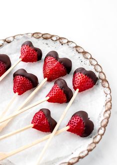 chocolate covered strawberries are arranged on skewers with toothpicks in the shape of hearts