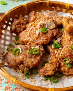 a basket filled with meat covered in sauce and green onions