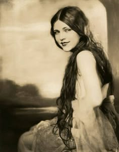 an old photo of a woman with long hair