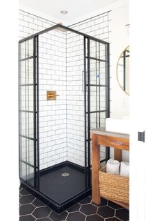 a black and white tiled bathroom with a stand up shower