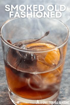 a glass filled with liquid and an orange slice on top of it, next to the words smoked old fashioned